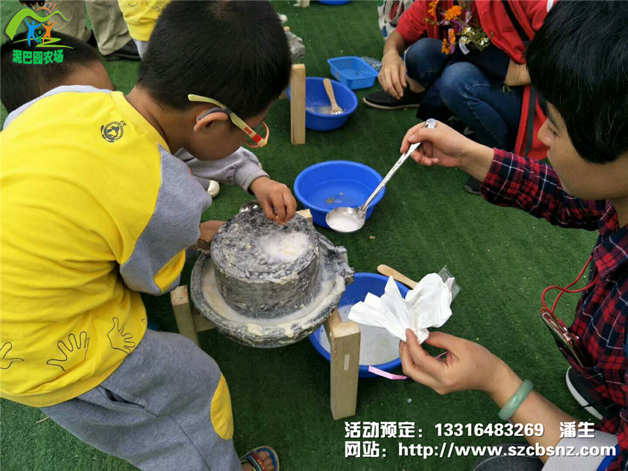 深圳亲子游基地泥巴园农场孩子们在父母指导下体验磨豆浆